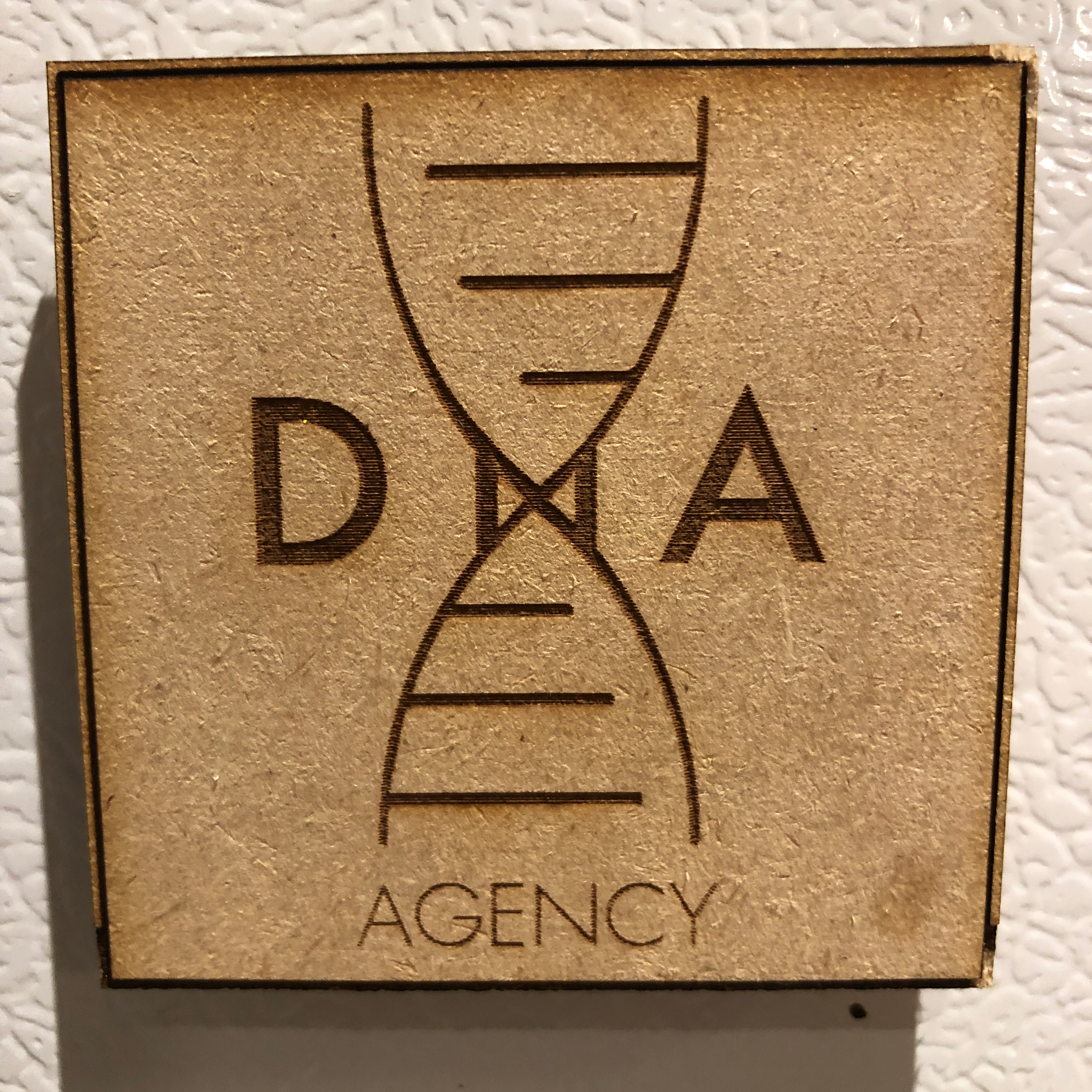 Custom brand magnets laser-cut with corporate logo for DNA Agency.